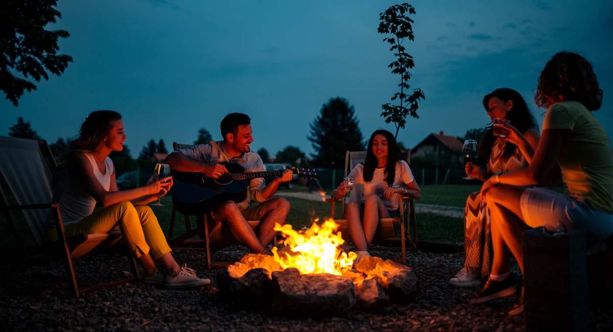 Firewood Link image with people sitting around a campfire